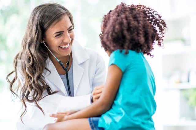 Female doctor caring for young girl